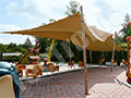 Une tente extensible de couleur sable montée sur une terrasse